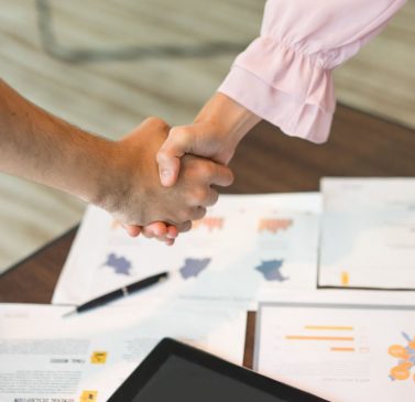 close-up-male-female-hands-handshake-documents (1)