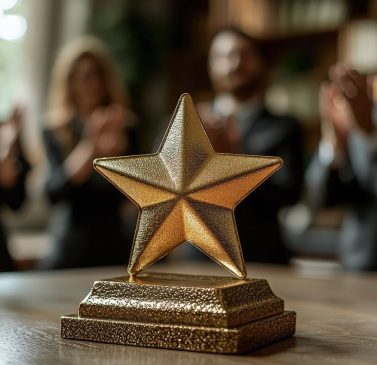 golden-star-award-trophy-wooden-table-with-blurred-people-applauding-background (1)